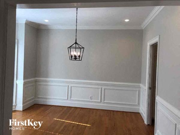a empty dining room with a light hanging from the ceiling
