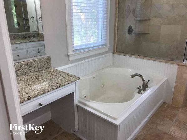 a bathroom with a tub and a sink and a mirror