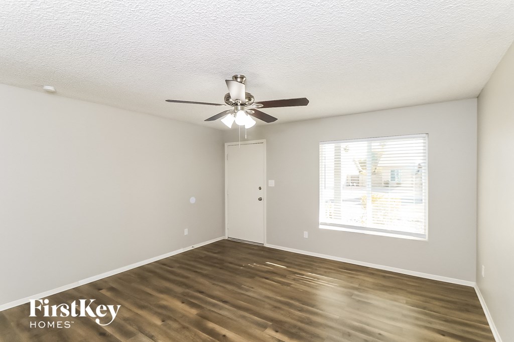 a living room with a ceiling fan and a window