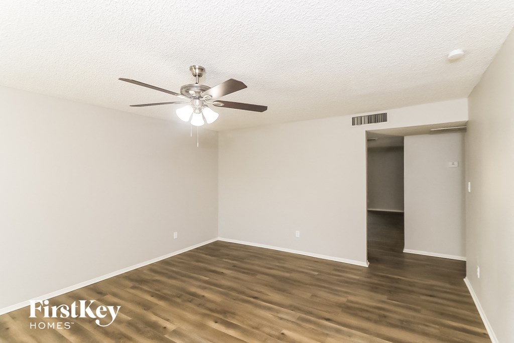 a living room with wood flooring and a ceiling fan