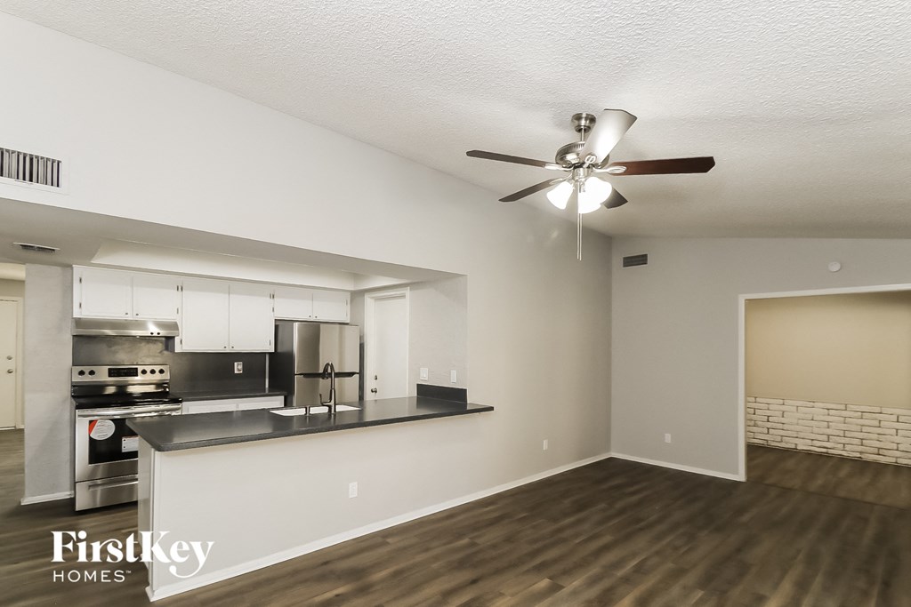 an open kitchen and living room with a ceiling fan