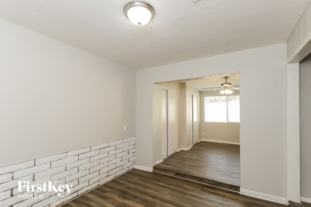 a renovated living room with a white brick wall and wood flooring