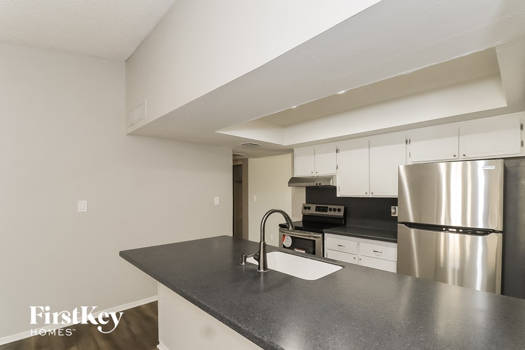 a kitchen with black counter top and stainless steel appliances