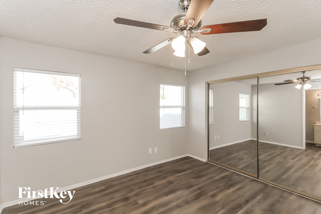 a living room with a ceiling fan and a mirror