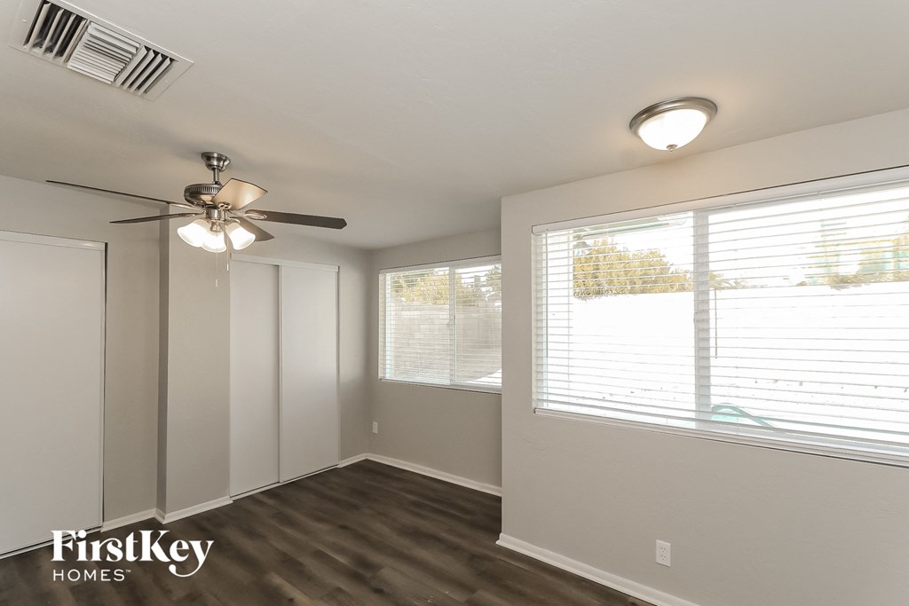 the living room has a large window and a ceiling fan