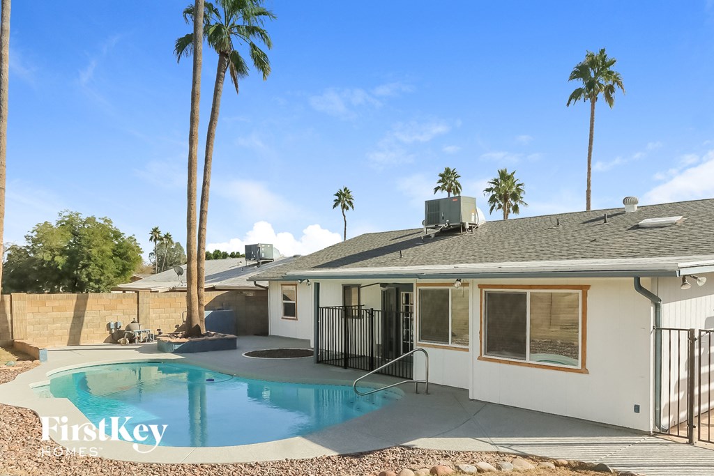 a house with a pool and palm trees