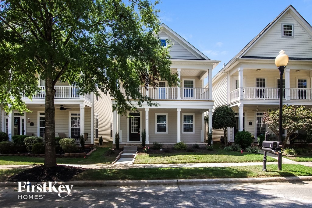 a large white house with a tree in front of it