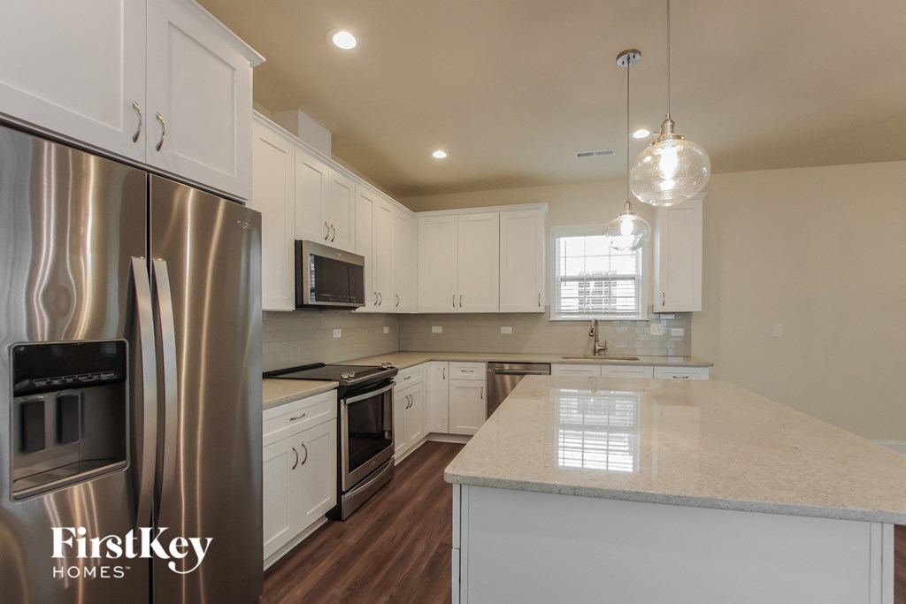 a kitchen with white cabinets and stainless steel appliances and a white counter top