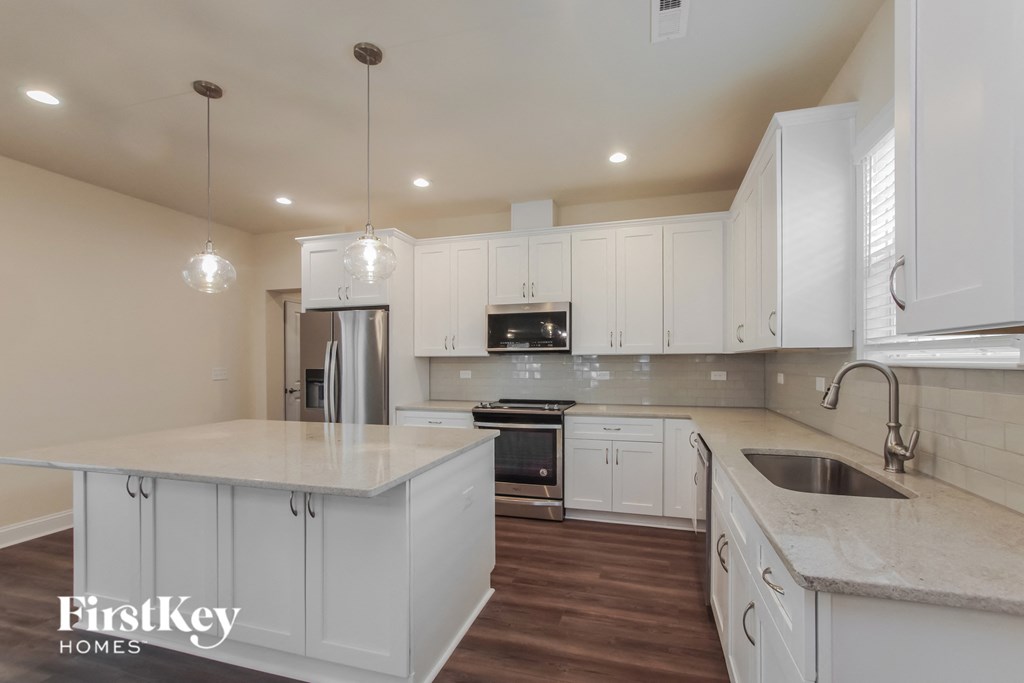 a large kitchen with white cabinets and white counter tops