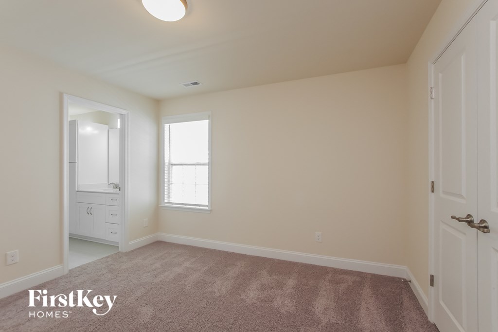 a master bedroom with a closet and a door to a bathroom