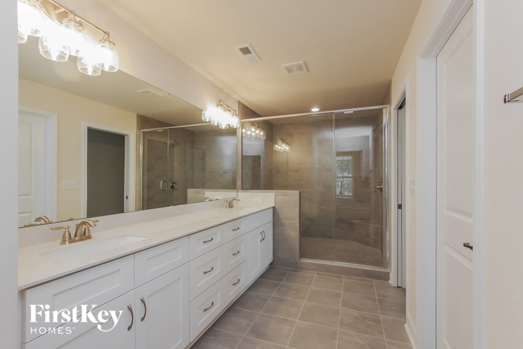 a large white bathroom with a large shower and a long counter top with a sink