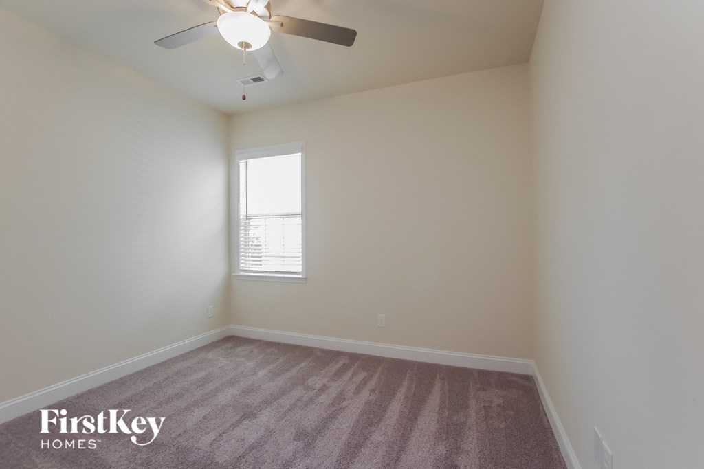 a bedroom with a ceiling fan and a window