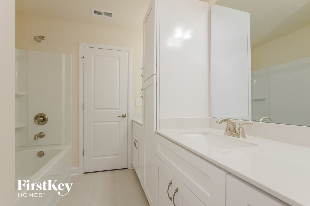 a bathroom with a sink and a shower and a door