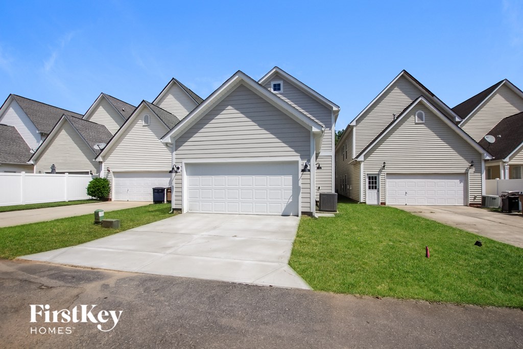 an empty driveway in front of a row of houses