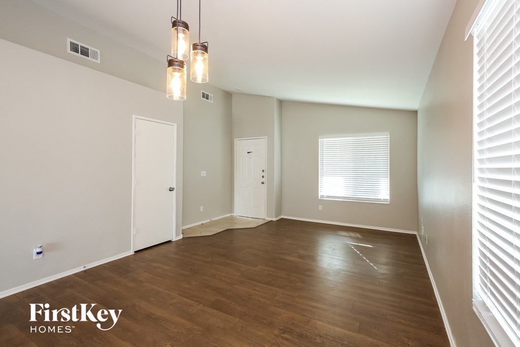 an empty living room with wood floors and white walls