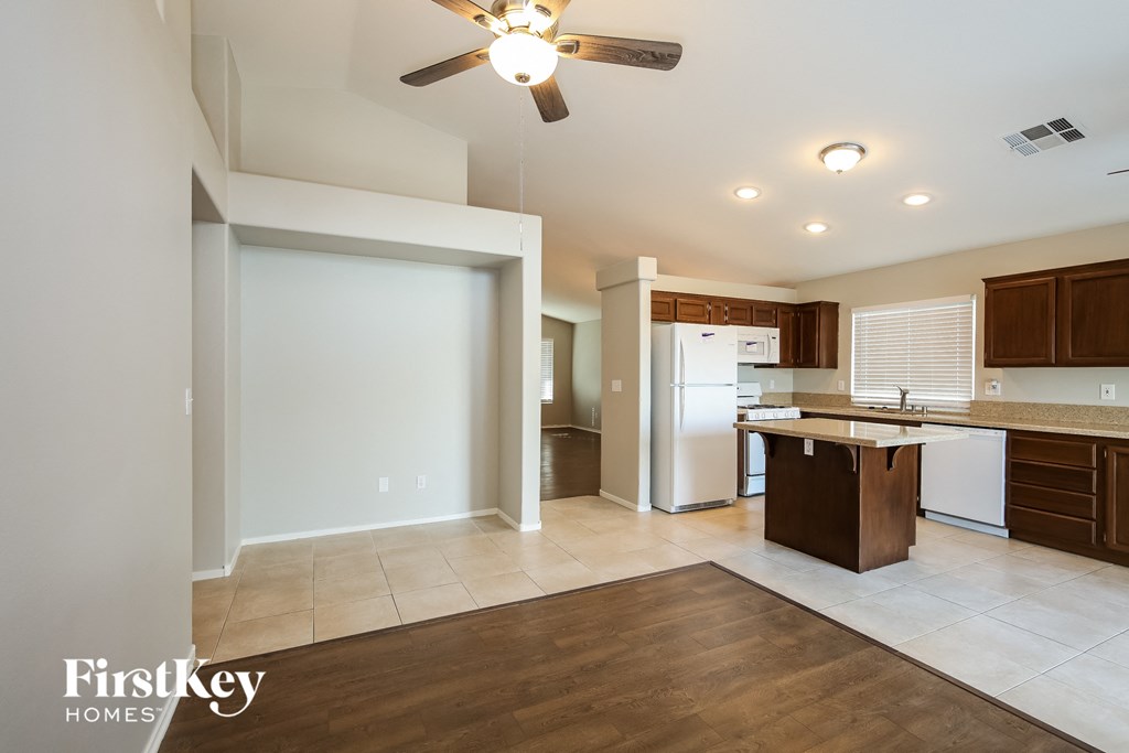 an empty kitchen and living room with a ceiling fan