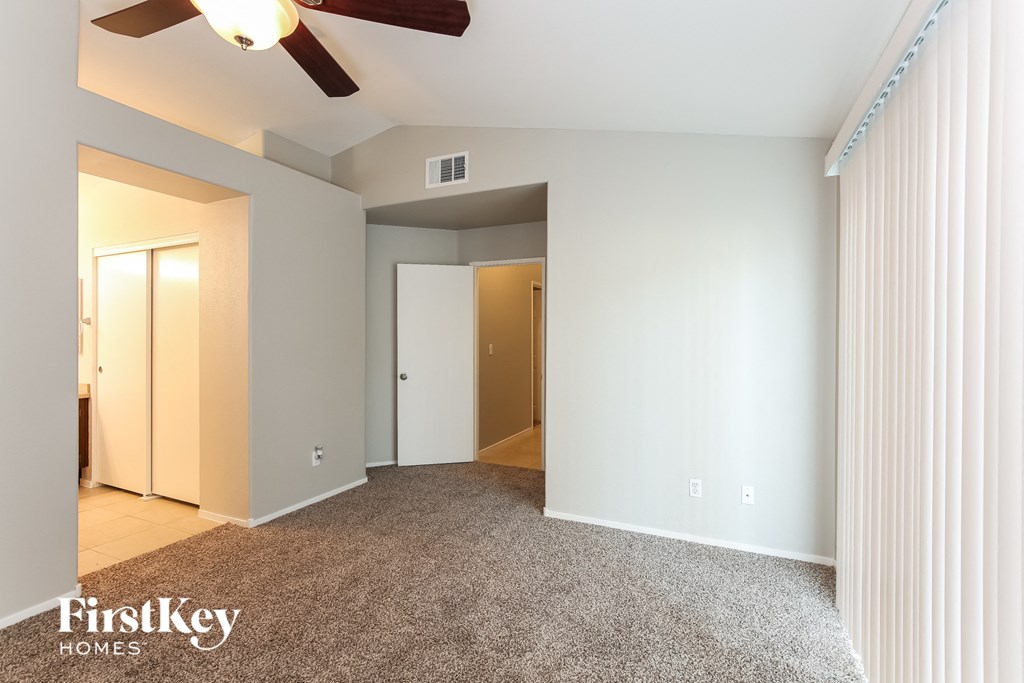 a master bedroom with a carpeted floor and a ceiling fan
