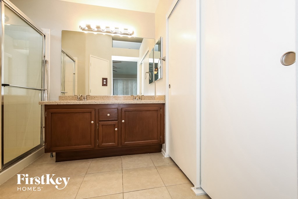 a bathroom with a sink and a shower and a mirror