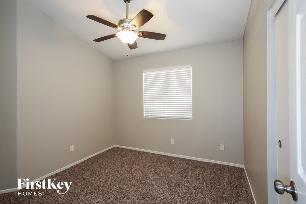 a empty room with a ceiling fan and a window