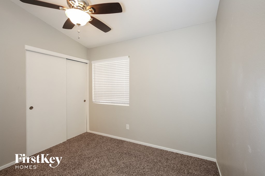a bedroom with a ceiling fan and a closet