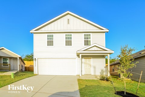 a white house with a sidewalk in front of it