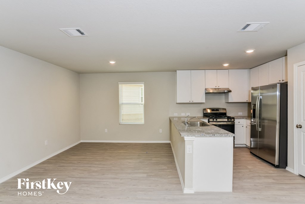 a kitchen with white cabinets and a stainless steel refrigerator
