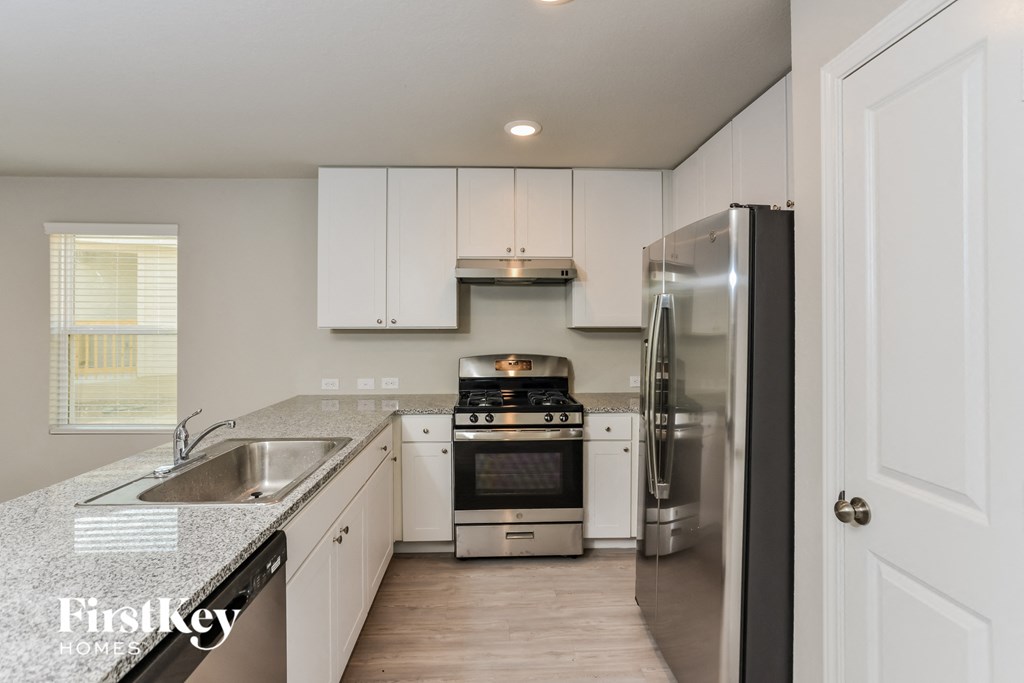 a kitchen with white cabinets and stainless steel appliances