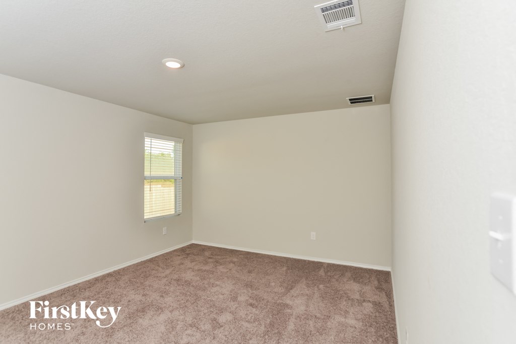 a bedroom with a carpeted floor and a window