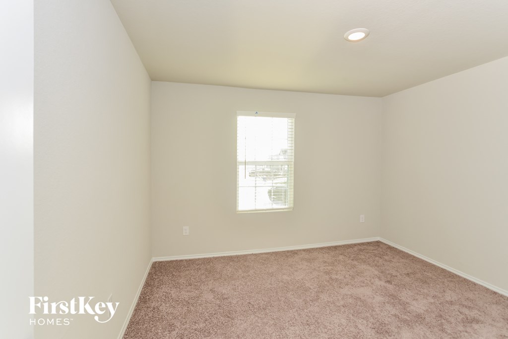 an empty room with carpet and a window