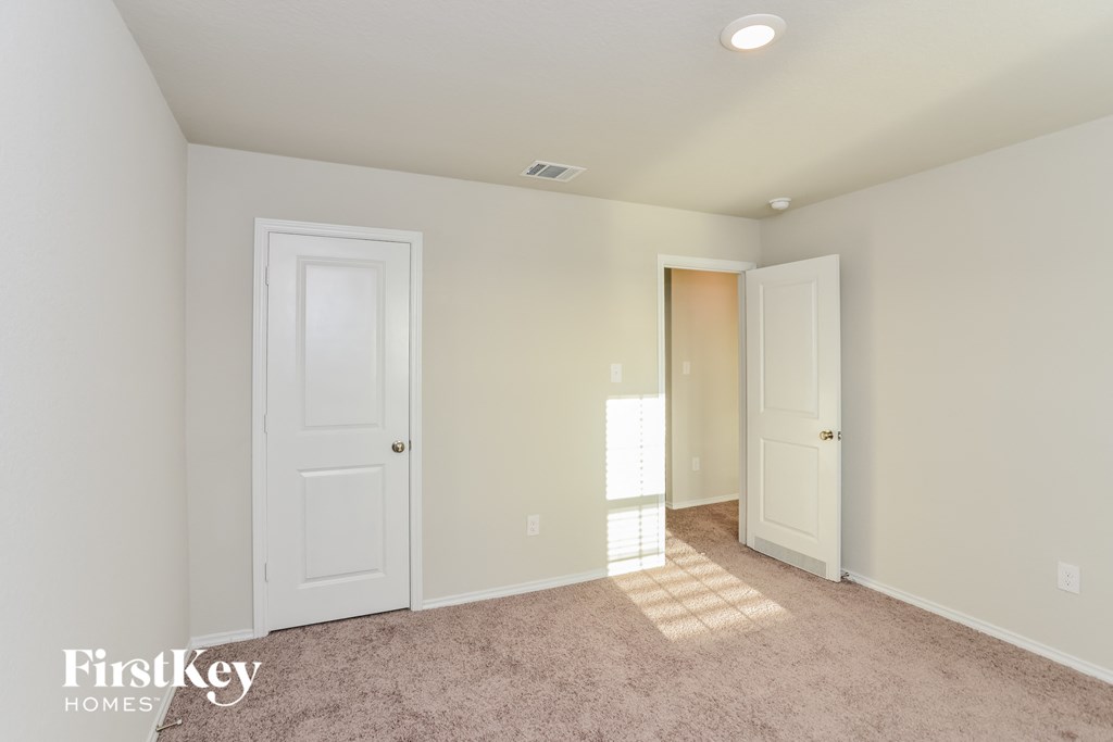 a bedroom with two closets and a door to a hallway