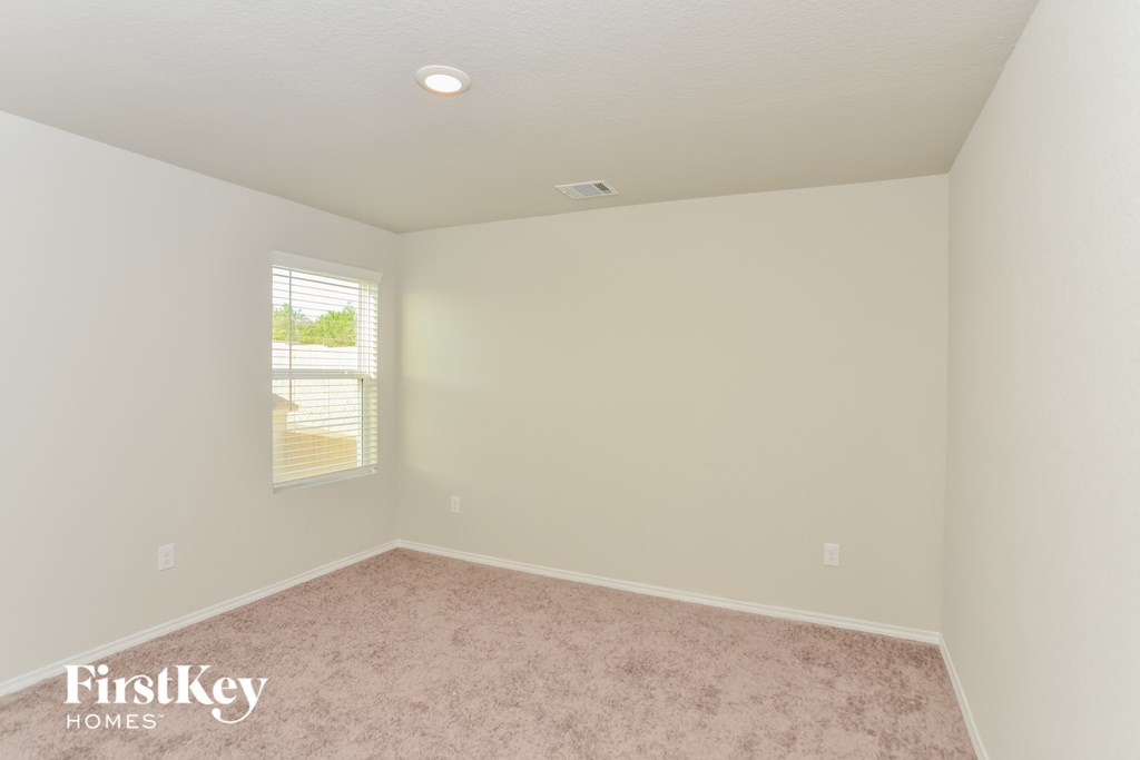 a bedroom with a carpet and a window