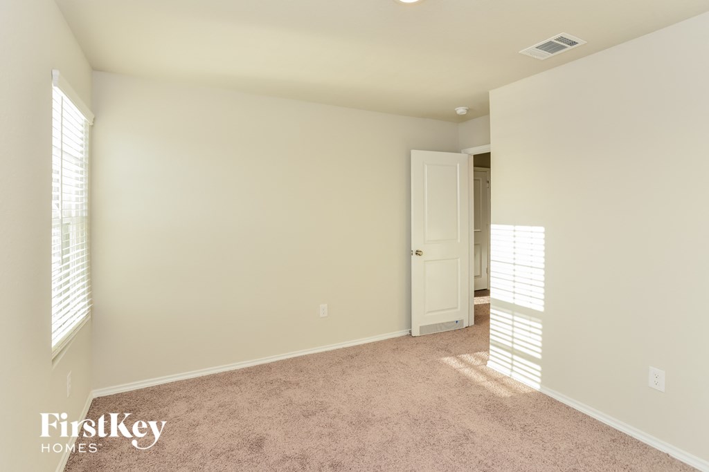 a bedroom with a carpeted floor and a door to a closet