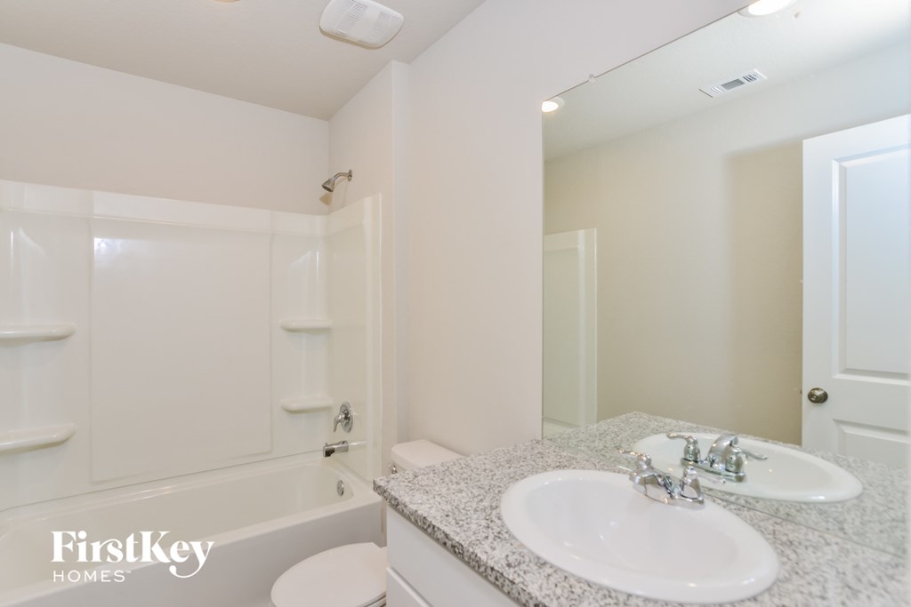 a bathroom with a sink and a tub and a mirror