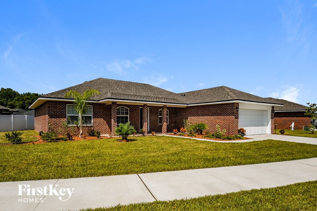 a brick house with a lawn and a garage