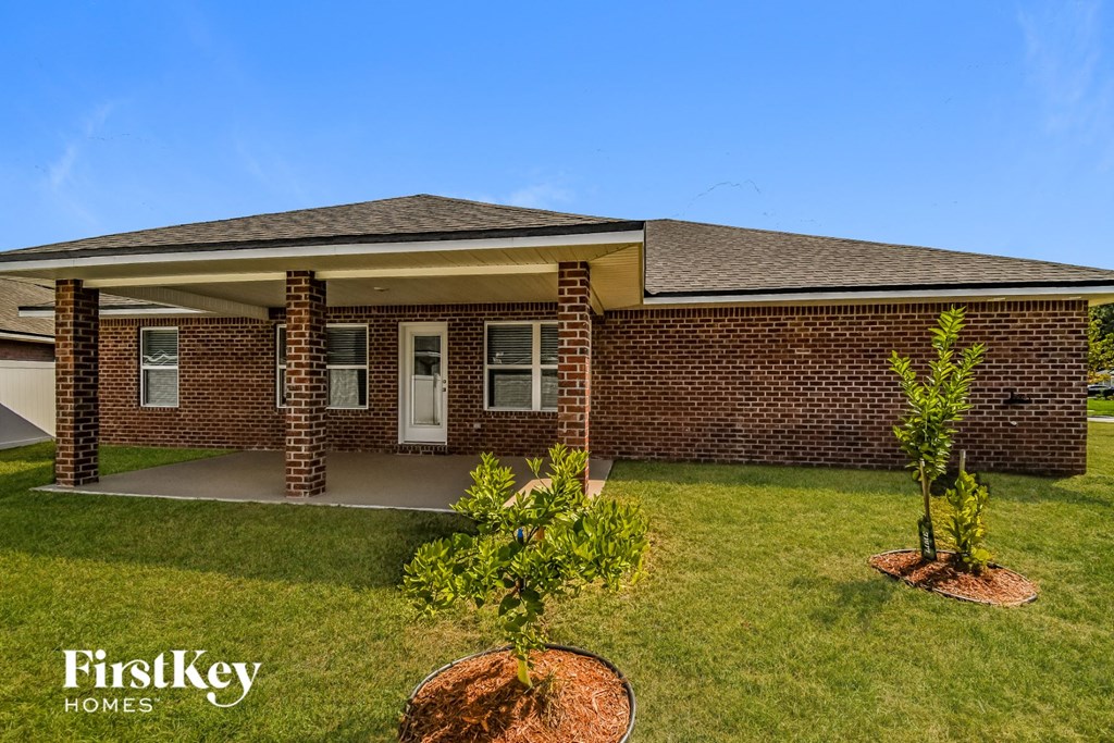 a small brick house with a yard and grass