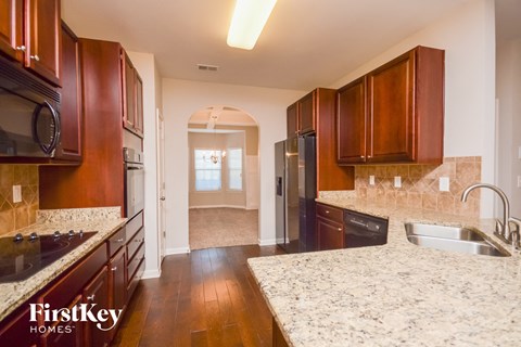 A kitchen with wooden cabinets and a granite countertop.