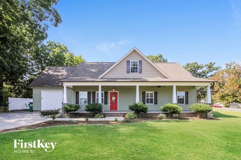 a white house with a red door on a lawn