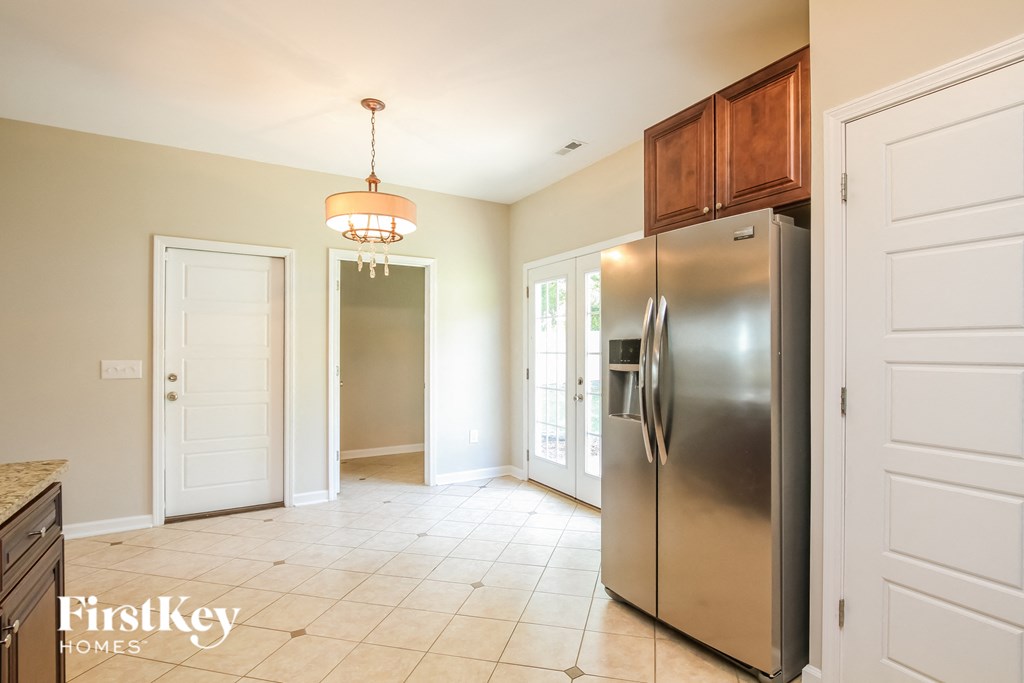 a kitchen with a stainless steel refrigerator and a door to a hallway