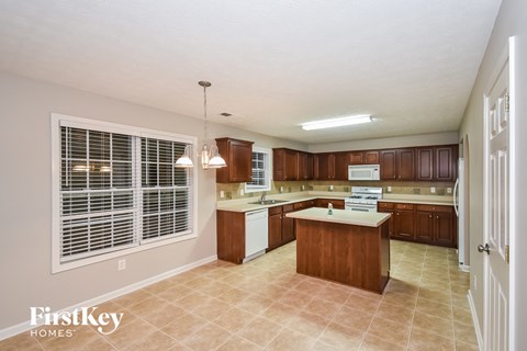 A kitchen with wooden cabinets and a large island.