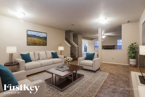 A well-lit living room with a large painting on the wall and a coffee table in the center.