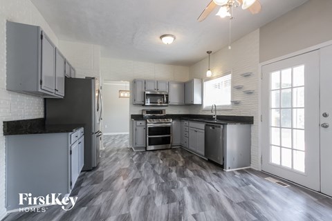 a renovated kitchen with stainless steel appliances and a hardwood floor