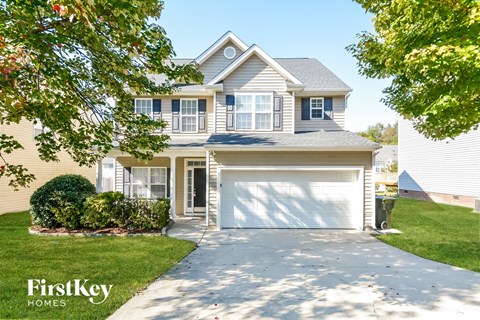 a white house with a garage door on a driveway