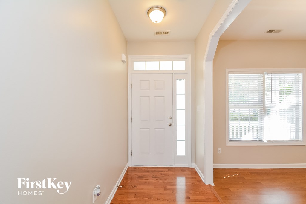 an empty room with a white door and a window