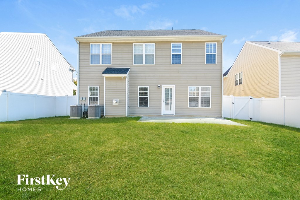 a beige house with a yard in front of it