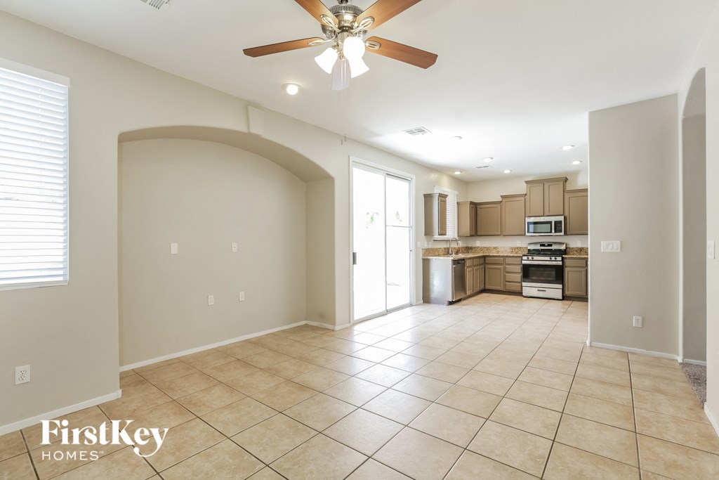 an empty kitchen and living room with a ceiling fan