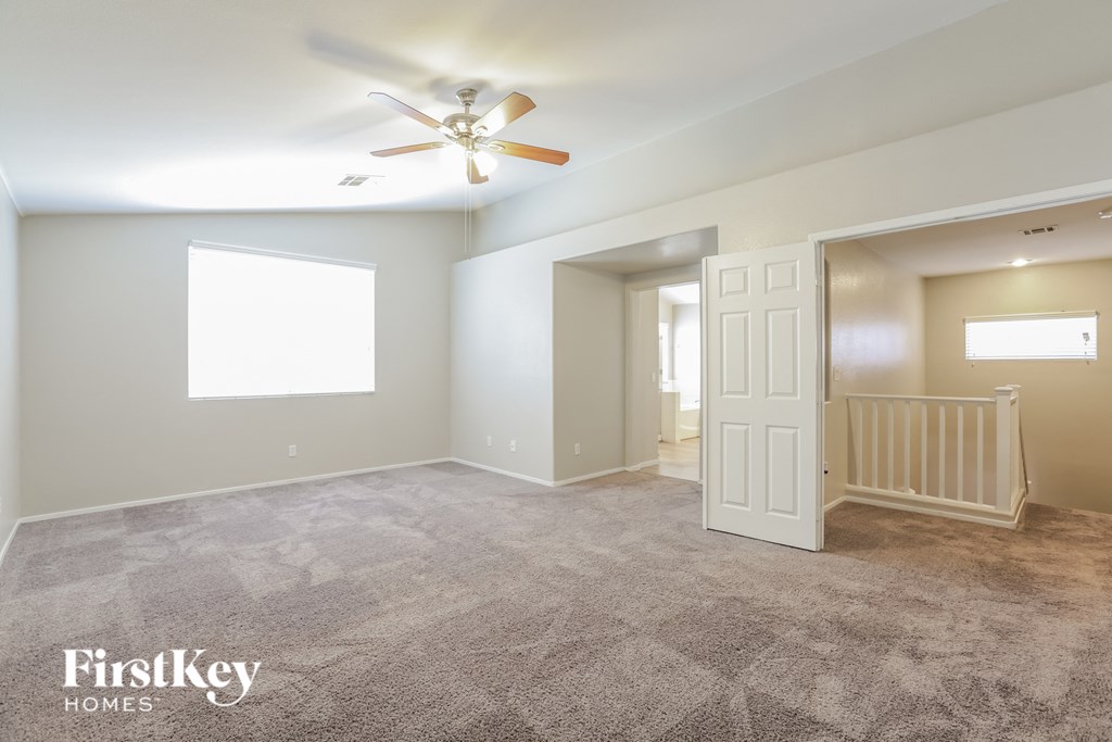 a living room with carpet and a ceiling fan