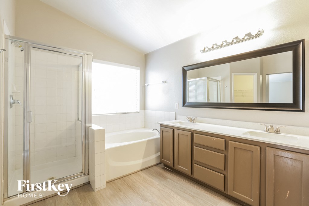 a bathroom with a shower and a sink and a mirror