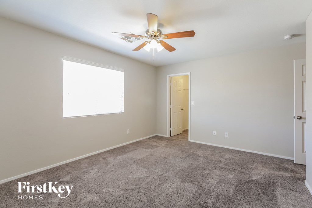 a living room with carpet and a ceiling fan