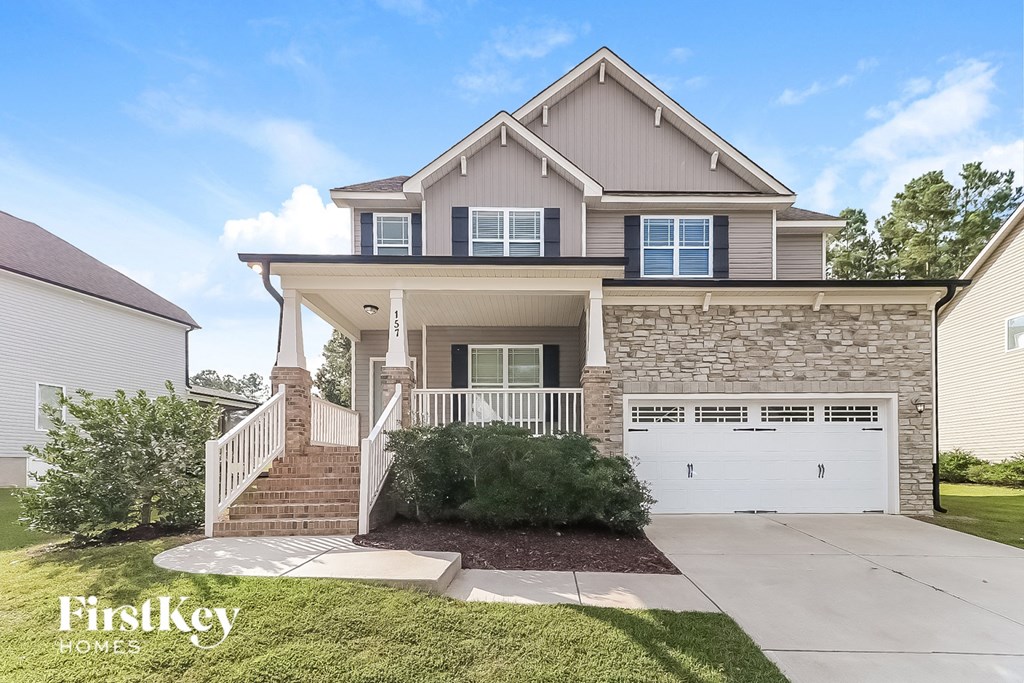 a home with a white garage door and a brick house