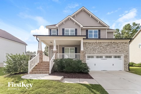 a home with a white garage door and a brick house